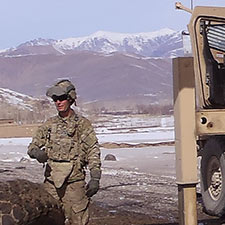 Steven Staggenborg directing a crane while leading recovery of a destroyed US vehicle outside a base in Afghanistan.